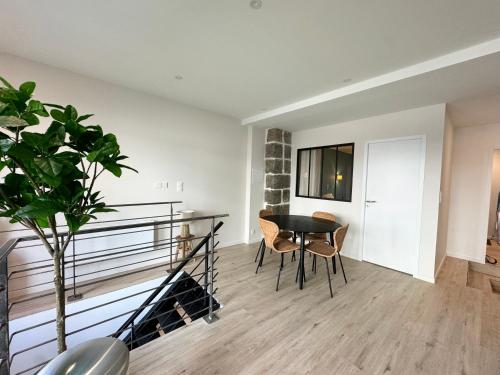 - un salon avec une table, des chaises et une plante dans l'établissement Appartement Cosy en Centre-Ville, à Brest
