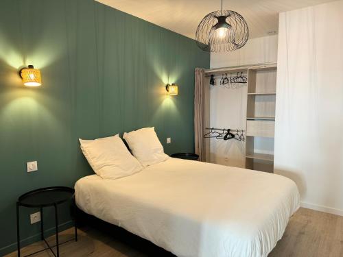une chambre avec un lit blanc et un mur vert dans l'établissement Appartement Cosy en Centre-Ville, à Brest