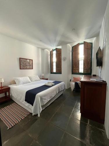 a bedroom with a bed and a television in it at Casa da Matriz Centro Histórico in Paraty