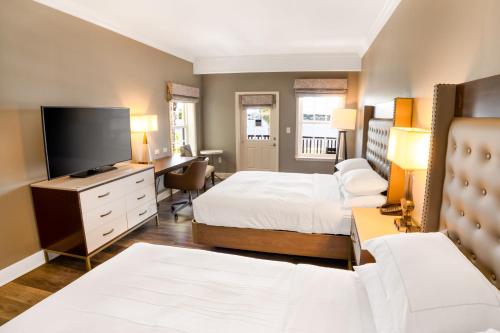 a hotel room with two beds and a flat screen tv at Hilton Saint Augustine Historic Bayfront in Saint Augustine