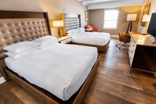 a hotel room with two beds and a desk at Hilton Saint Augustine Historic Bayfront in Saint Augustine