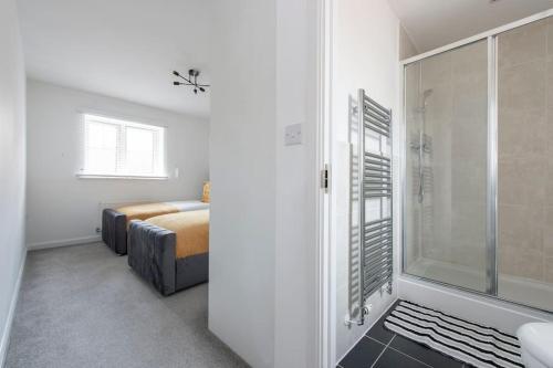 a bathroom with a shower and a bedroom with a bed at Luxury 2 bed house in Dartford, United Kingdom in Dartford