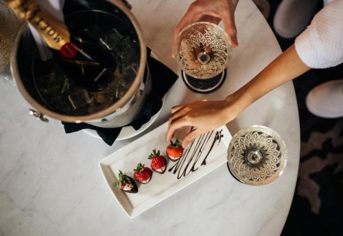 a person cutting a plate of strawberries on a table at The Read House Hotel in Chattanooga