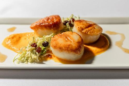 a plate of food with scallops and a salad at The Read House Hotel in Chattanooga