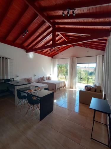a living room with a couch and a table at Cabanas Privativas com Jacuzzi, Cozinha, Churrasqueira e Decoração - Sitio Pauletto in Jarinu
