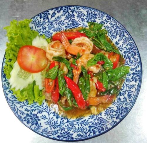 a blue and white plate of food with shrimp and vegetables at Tara Lake in Bangkok