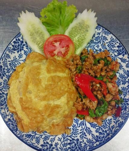 a blue and white plate of food with a omelet and vegetables at Tara Lake in Bangkok