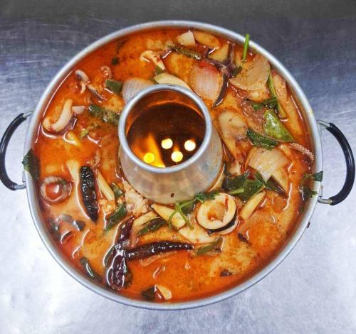 a bowl of soup with a spoon in it at Tara Lake in Bangkok