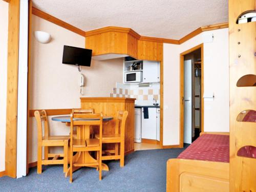 une cuisine avec une table et des chaises dans une pièce dans l'établissement Résidence Chamois - Studio pour 4 Personnes 114, à Aime La Plagne