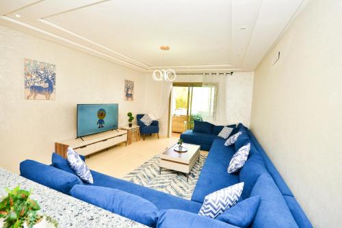 un soggiorno con divani blu e TV di Modern Marina - Beach - Pool a Sidi Rahal