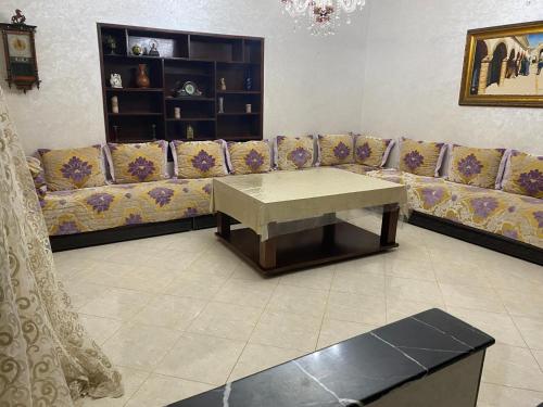 a living room with a couch and a coffee table at Villa Mly Saïd in Sidi Bouzid