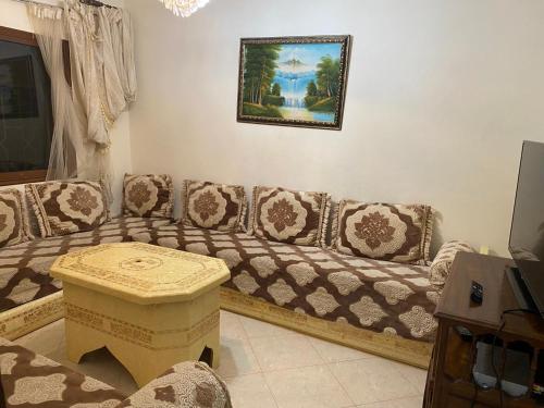 a living room with a couch and a picture on the wall at Villa Mly Saïd in Sidi Bouzid