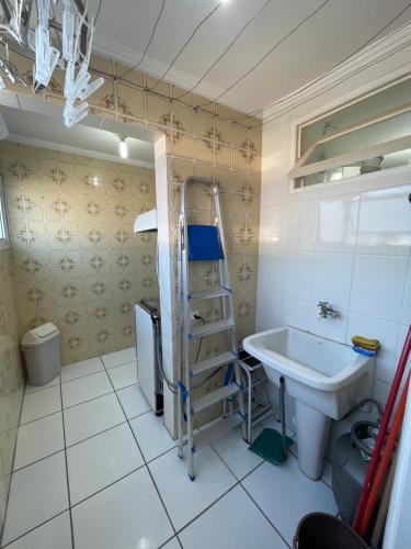 a bathroom with a sink and a ladder next to a toilet at Excelente AP na Orla de Ubatuba in Ubatuba