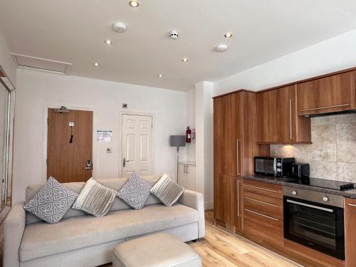 a living room with a couch and a kitchen at Granada Apartments Berkeley in Blackpool