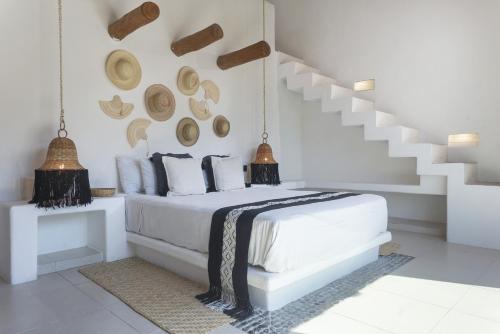 a white bedroom with a bed and a staircase at Casa Lucio I Puerto Aventuras I Private Pool in Puerto Aventuras