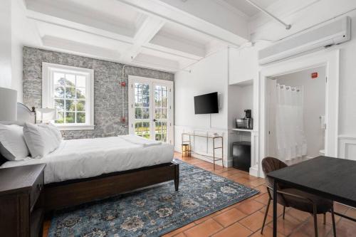 a bedroom with a bed and a desk and a table at Stonehouse Inn, Santa Rosa - Private King Suite # 3 in Santa Rosa