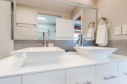 a white bathroom with two sinks and a mirror at 104 World of Tennis Square #104 in Lakeway