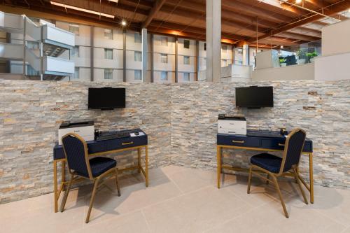 a lobby with two desks and two chairs at Ramada by Wyndham DFW Airport in Irving