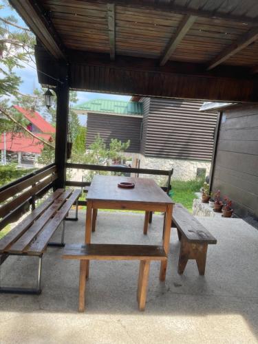 a picnic table and benches on a patio at Vikendica Malović in Žabljak