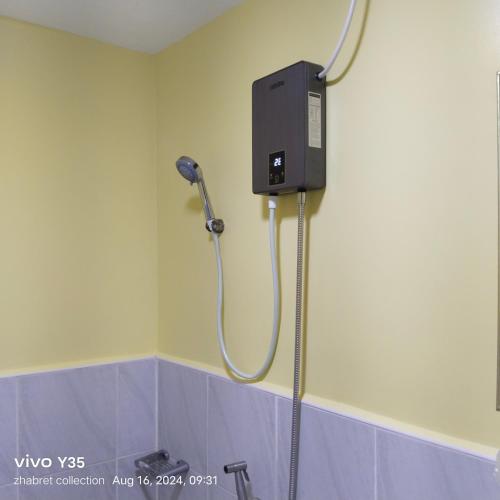 a shower in a bathroom with a blow dryer at Zhabret's Place II in Lapu Lapu City