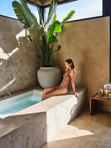 a woman in a bathing suit sitting on a bath tub at Stanly Ranch, Auberge Collection in Napa