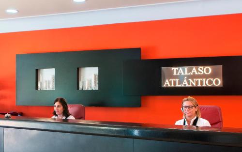 two women sitting at a counter in an airport at Talaso Atlántico in Mougás