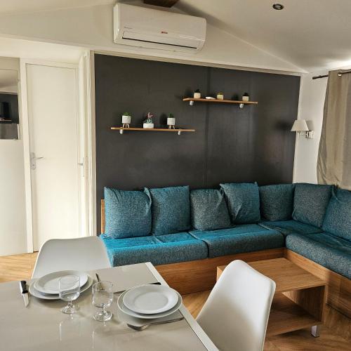 un salon avec un canapé bleu et une table dans l'établissement Siblu, à Fréjus