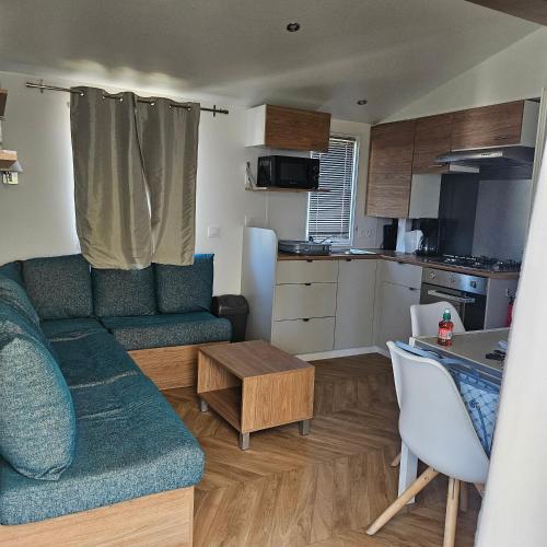 un salon avec un canapé et une cuisine dans l'établissement Siblu, à Fréjus