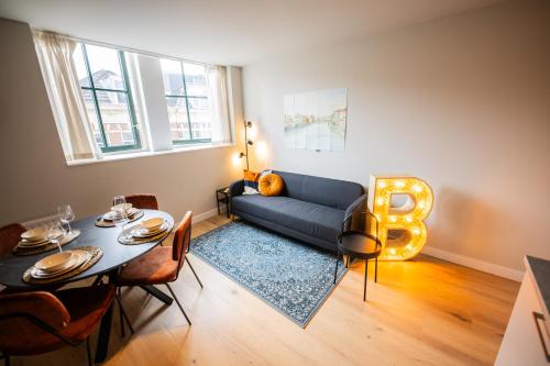 a living room with a blue couch and a table at Alphabet Apartments -2e Pijnackerstraat 13 in Rotterdam
