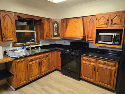 a kitchen with wooden cabinets and a black stove top oven at Unit 2 at Oilgate at Oakdale in Akron