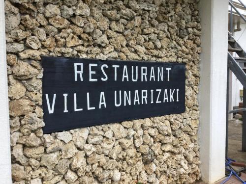 a sign on the side of a stone wall at Villa Unarizaki in Iriomote