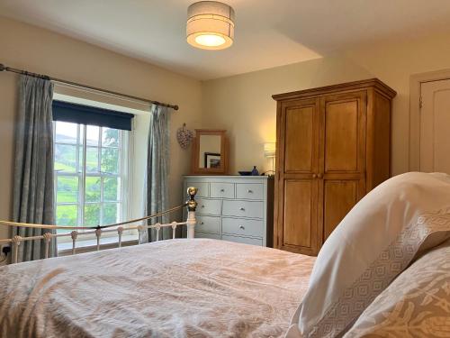 雷克瑟姆Plas yn Yale with mountain views from all windows的带床、梳妆台和窗户的卧室