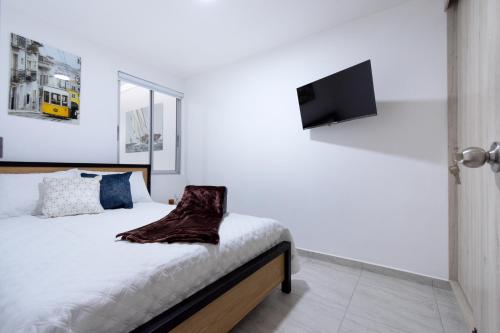 a bedroom with a bed with a television on the wall at Refugio Moderno para descansar en Santa Rosa in Santa Rosa de Cabal
