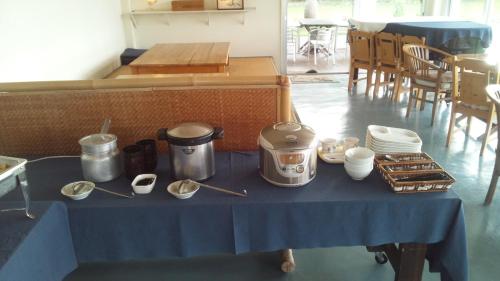 a table with a blue table cloth with utensils on it at Villa Unarizaki in Iriomote