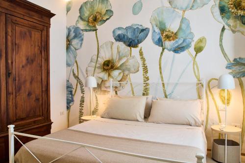 a bedroom with a bed with blue flowers on the wall at Dormi da noi in Ancona