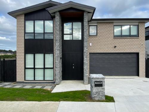 a brick house with a black garage at Extra-Large Brand-New House, Over 400sqm in Auckland