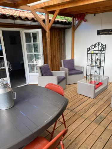 a patio with a table and chairs on a wooden deck at CHALET LOU PADER in Vézac