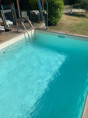 a large pool of blue water in a yard at CHALET LOU PADER in Vézac