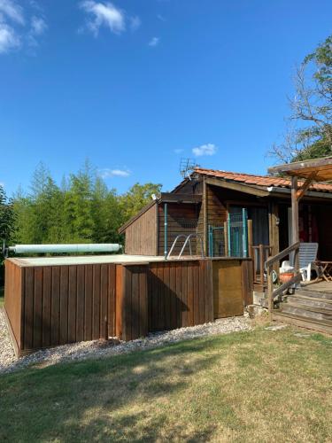 a house with a wooden fence and a deck at CHALET LOU PADER in Vézac