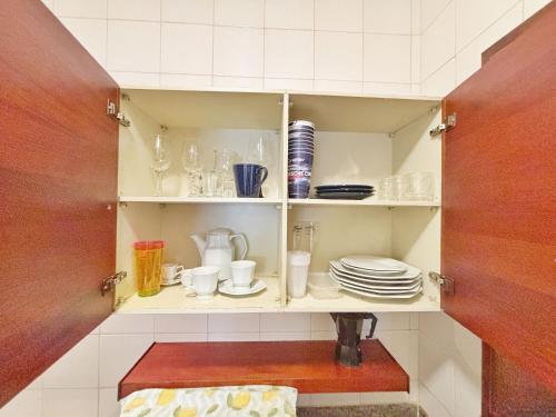 a cupboard filled with plates and cups and dishes at ENB | Flat hotel em SBC p/ 2 pp Espaço e Conforto in São Bernardo do Campo