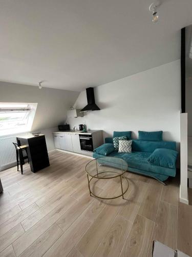 un salon avec un canapé vert et une table dans l'établissement STUDIO BORD DE MER LOMENER, à Ploemeur