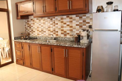 een keuken met een spoelbak en een koelkast bij Al-Sabah Residence Agadir in Agadir