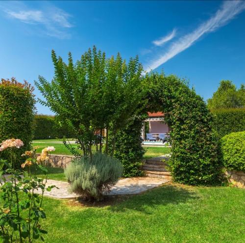 an archway in a garden with a bush at Apartmant Erman in Valdebek