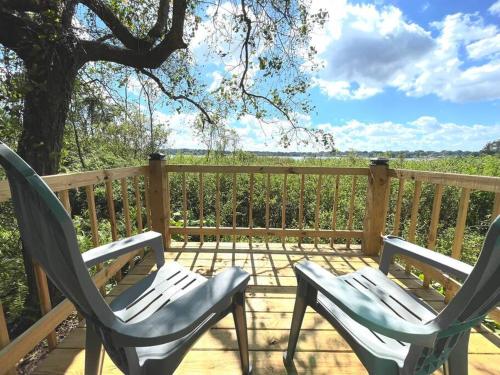 two chairs sitting on a deck with a view at 1Bed 1Bath Container Home Centrally Located in Cypress Gardens