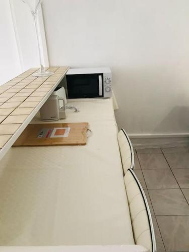un micro-ondes posé sur un comptoir dans une cuisine dans l'établissement logement tout proche de la plage, à Cannes