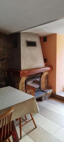 a stone fireplace in a room with a table and chairs at Rancho u Bolka in Miedzygorze