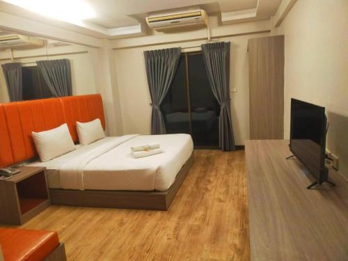 a bedroom with a bed and a flat screen tv at Tara Lake in Bangkok