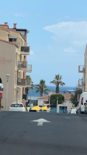 une rue urbaine vide avec des bâtiments et des palmiers dans l'établissement Mylilou location, au Cap d'Agde