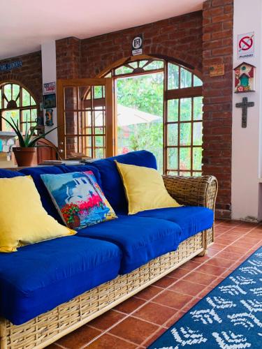 a blue couch in a room with a brick wall at La Casa del Rio B&B in Puyo