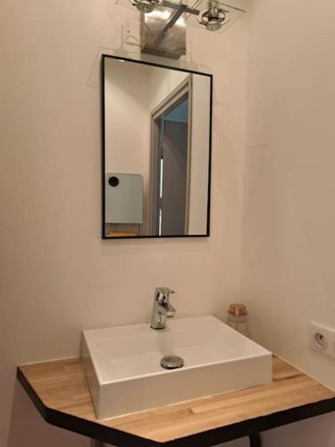 une salle de bain avec un lavabo blanc et un miroir dans l'établissement Dubonnet - Cœur de ville, à Brignoles